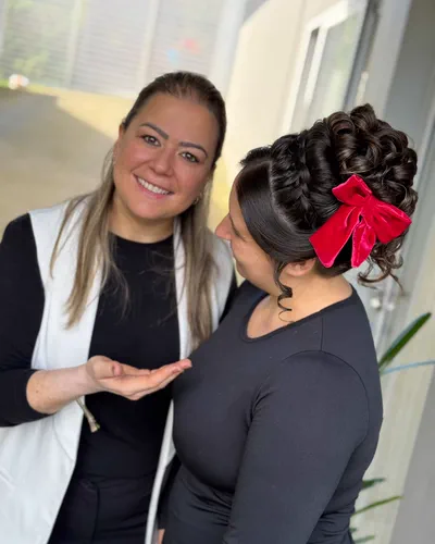 Penteado de cachos com laço vermelho, feito na imersão